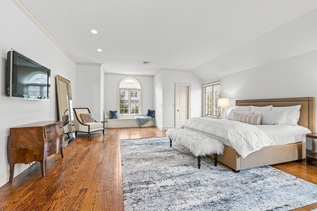 77 Cliff Road Wellesley, MA 02481 - Photo 22 of 33 a spacious bedroom with a bed a couch and large windows