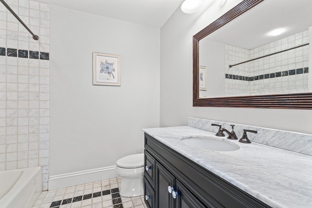 77 Cliff Road Wellesley, MA 02481 - Photo 24 of 33 a bathroom with a granite countertop sink a toilet and a mirror