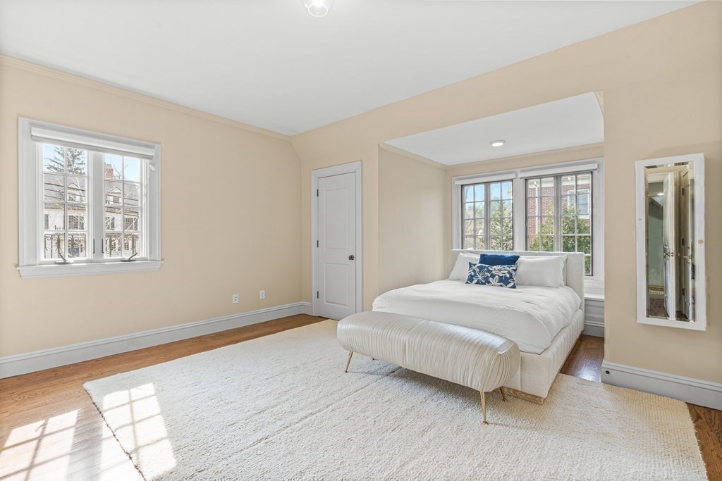 77 Cliff Road Wellesley, MA 02481 - Photo 25 of 33 a bedroom with a bed lamp and a large window