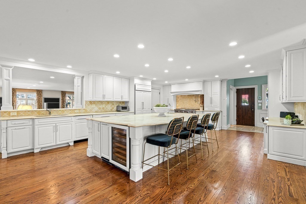 77 Cliff Road Wellesley, MA 02481 - Photo 8 of 33 a kitchen with stainless steel appliances granite countertop a table chairs sink refrigerator and cabinets