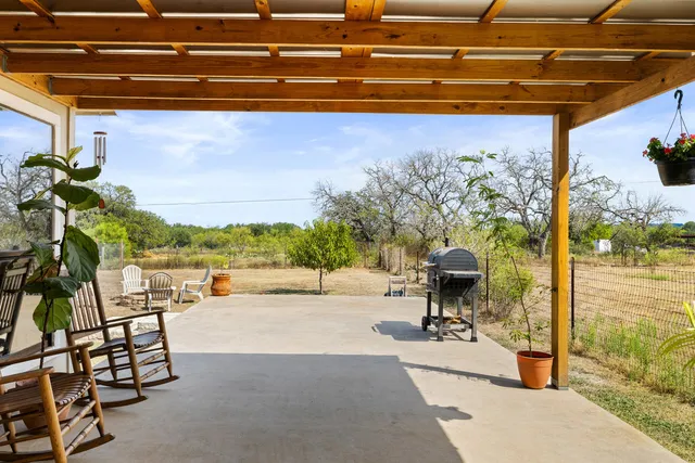 a view of a porch with furniture and a yard