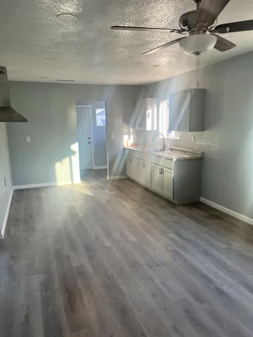 a large white kitchen with cabinets a sink and dishwasher