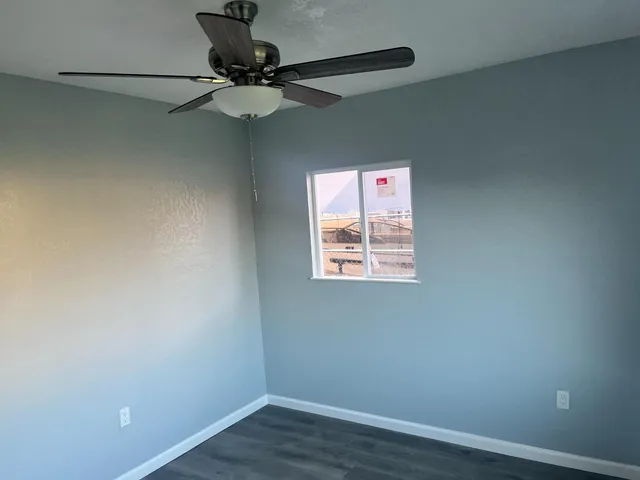 a view of a room with a fan and wooden floor