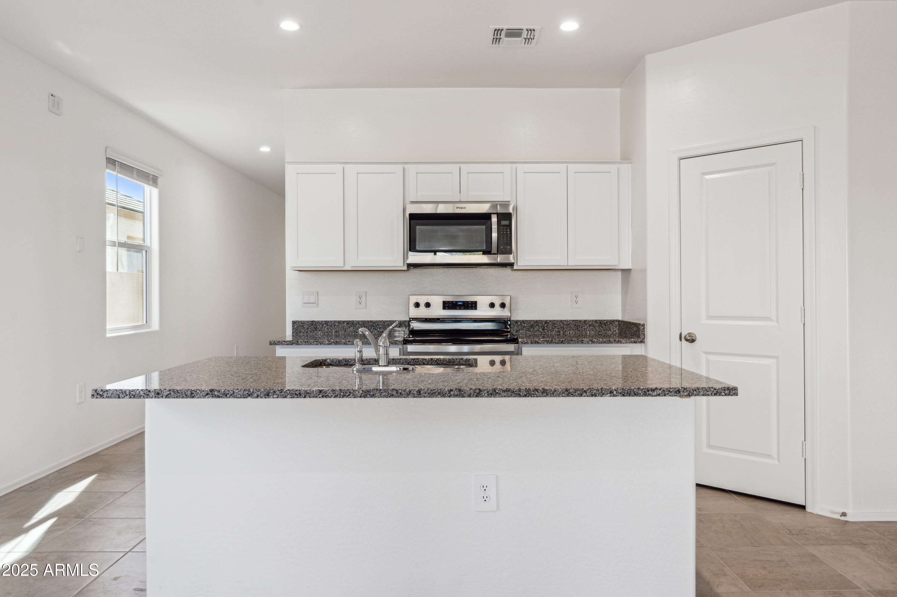 5072 East Umber Road San Tan Valley, AZ 85143 - Photo 12 of 41 a kitchen with granite countertop a sink a stove top oven and wooden floors