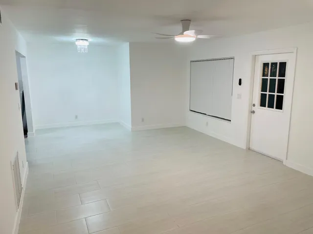 an empty room with fan and entrance
