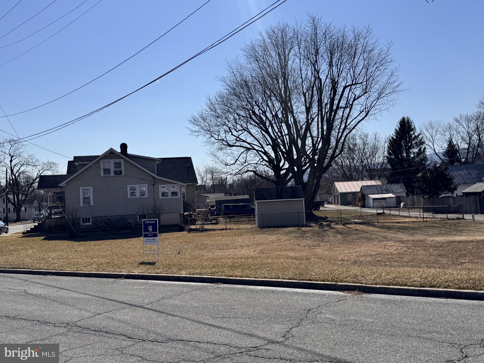 a view of a house with a large tree in the background