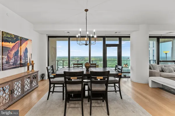 a dining room with furniture a chandelier and wooden floor