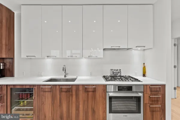 a kitchen with stainless steel appliances granite countertop a stove a sink and white cabinets
