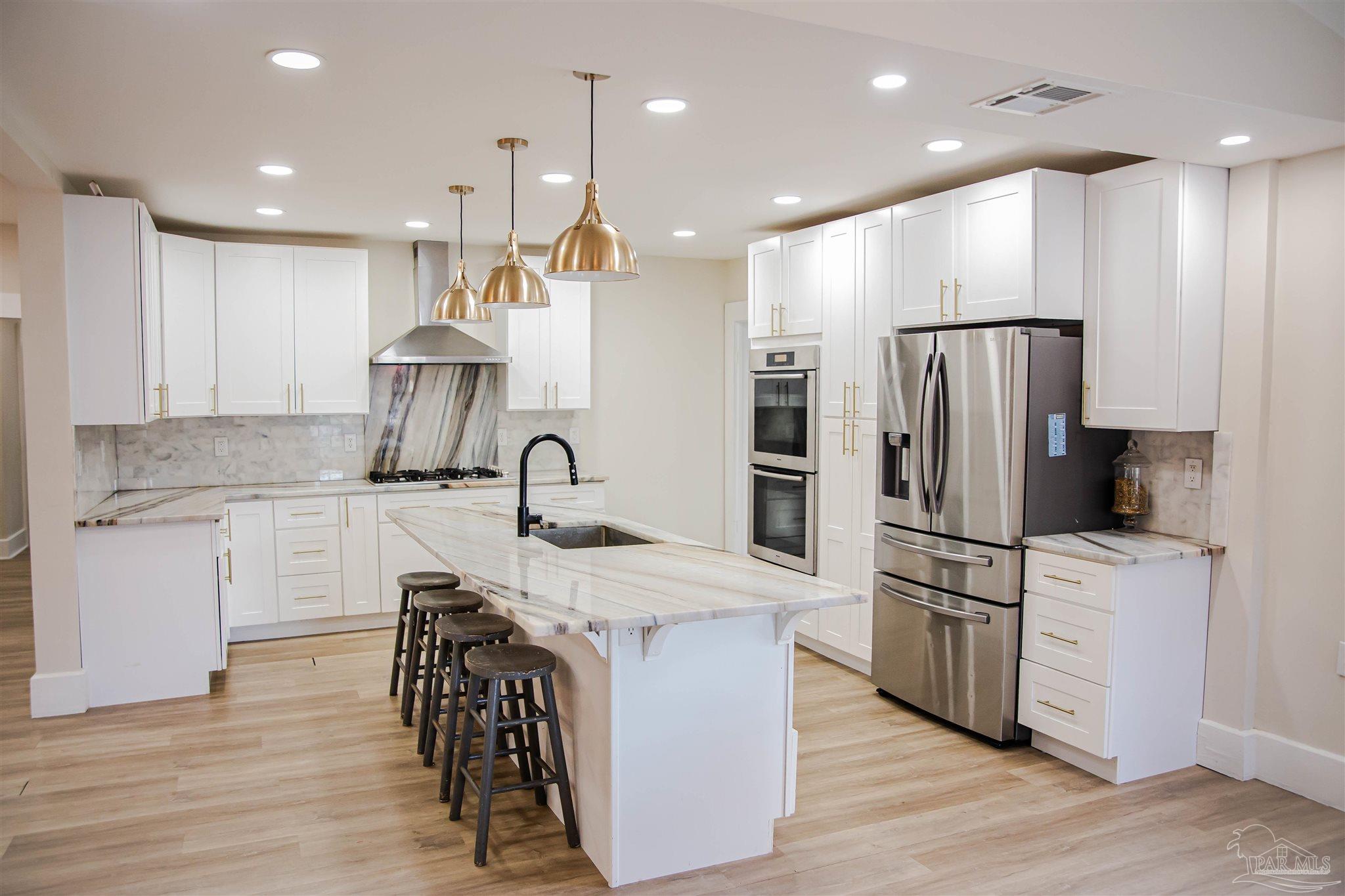5347 Stewart Street Milton, FL 32570 - Photo 6 of 20 a kitchen with kitchen island a sink stainless steel appliances and cabinets