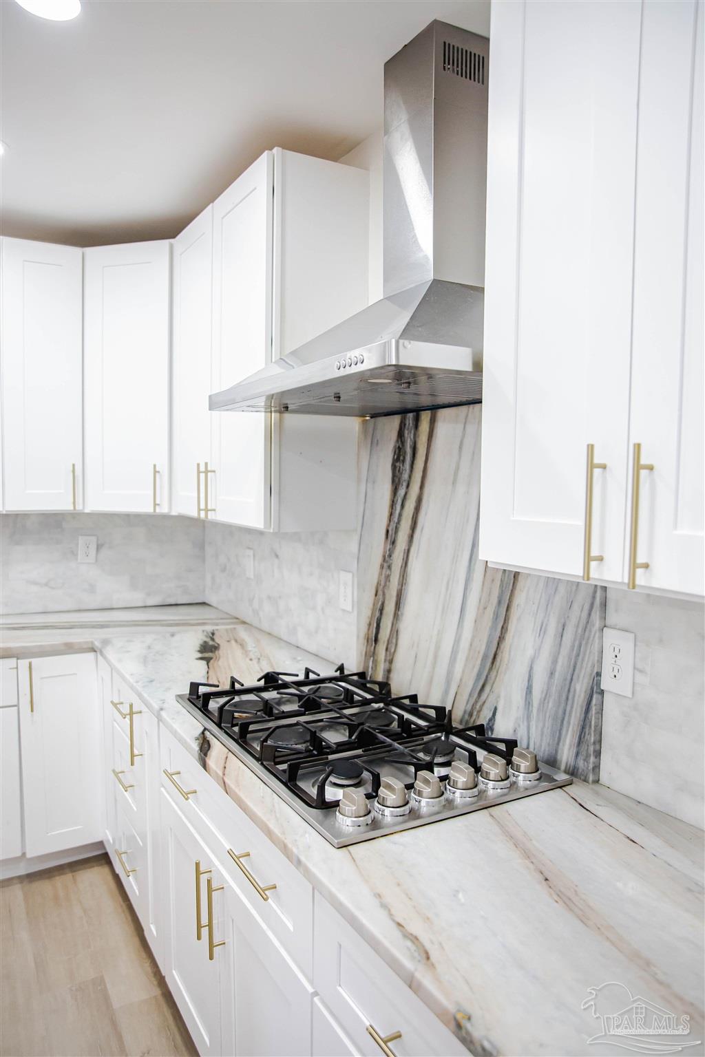 5347 Stewart Street Milton, FL 32570 - Photo 8 of 20 a kitchen with a stove and a white cabinet