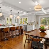 a kitchen with kitchen island granite countertop a table and chairs in it
