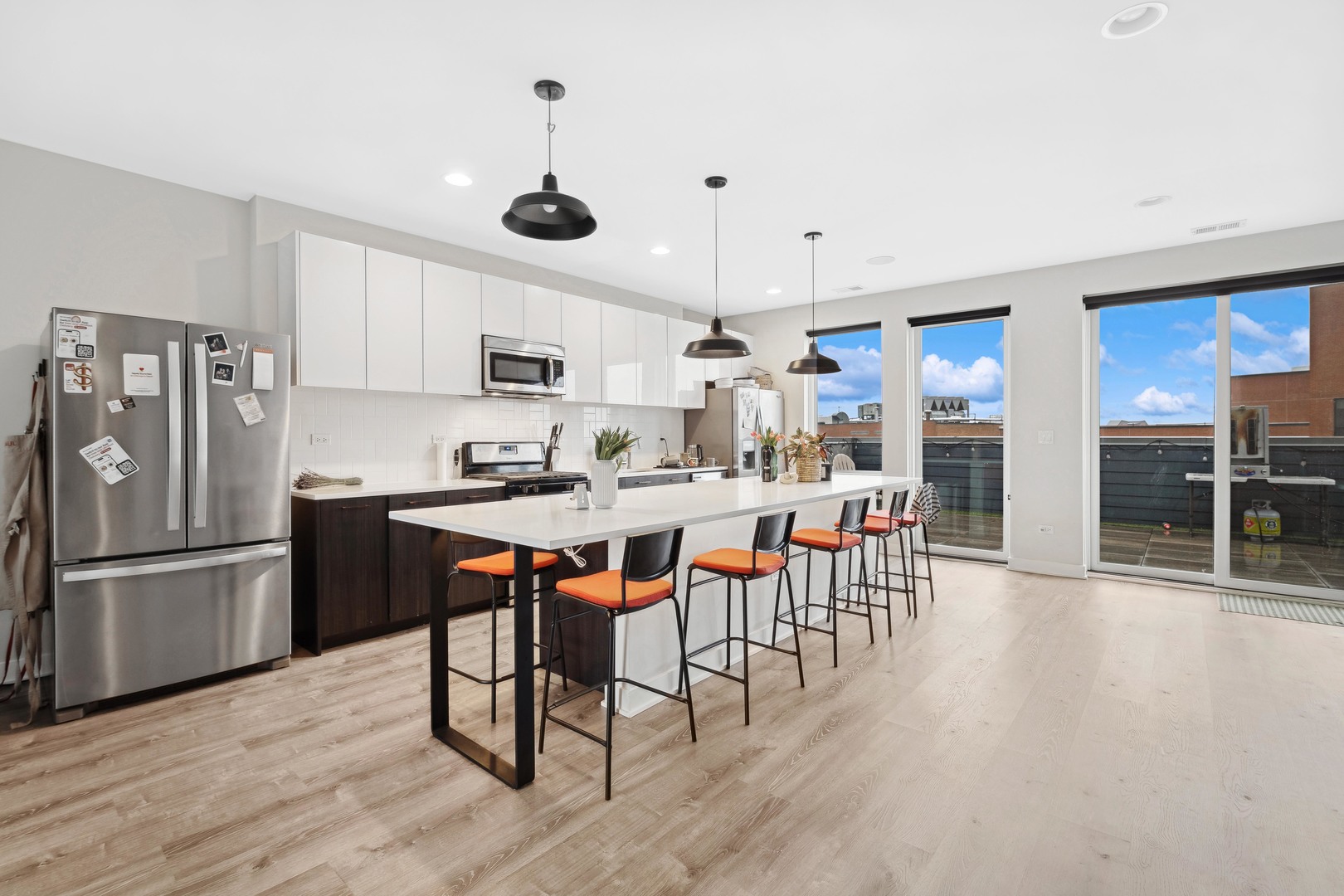 4027 North Broadway Chicago, IL 60613 - Photo 15 of 25 a kitchen with stainless steel appliances granite countertop a table chairs stove and refrigerator