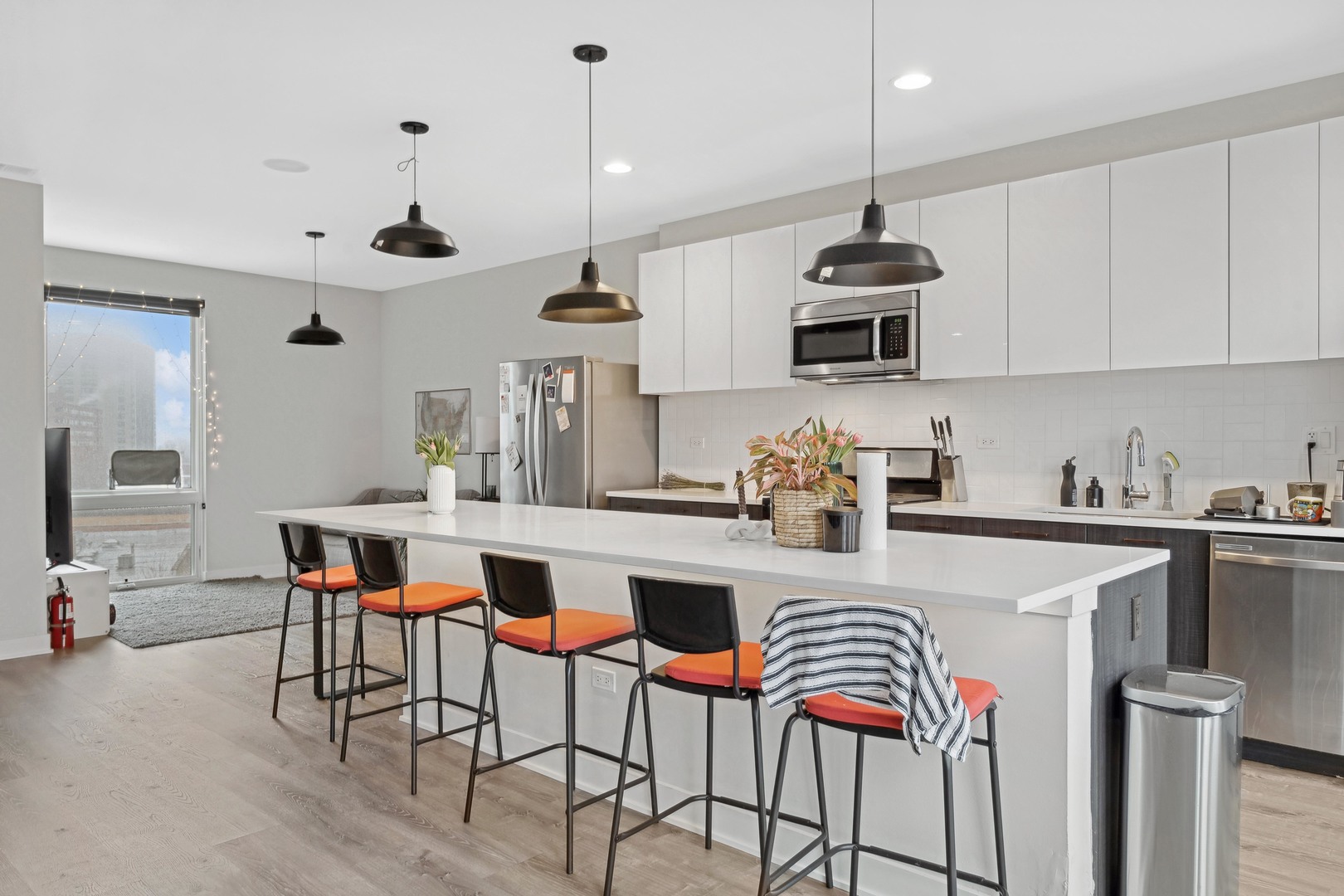 4027 North Broadway Chicago, IL 60613 - Photo 17 of 25 a kitchen with stainless steel appliances granite countertop a sink a stove and chairs