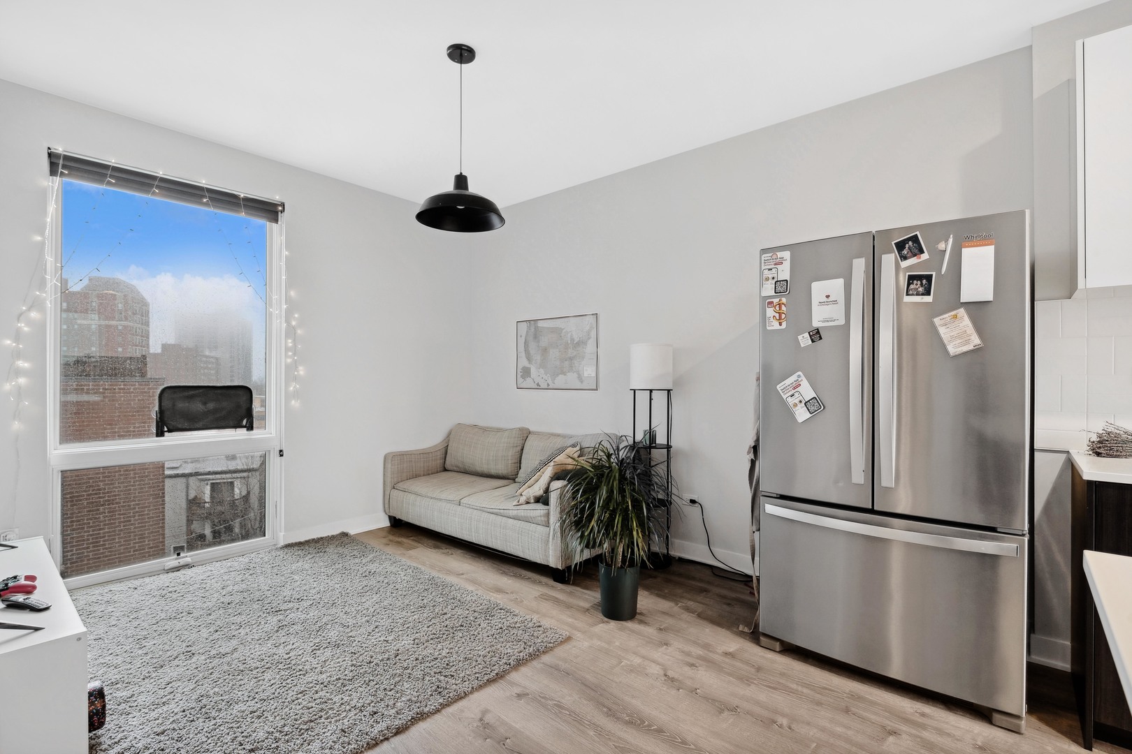 4027 North Broadway Chicago, IL 60613 - Photo 18 of 25 a kitchen with stainless steel appliances a refrigerator a stove a sink dishwasher a dining table and chairs with wooden floor