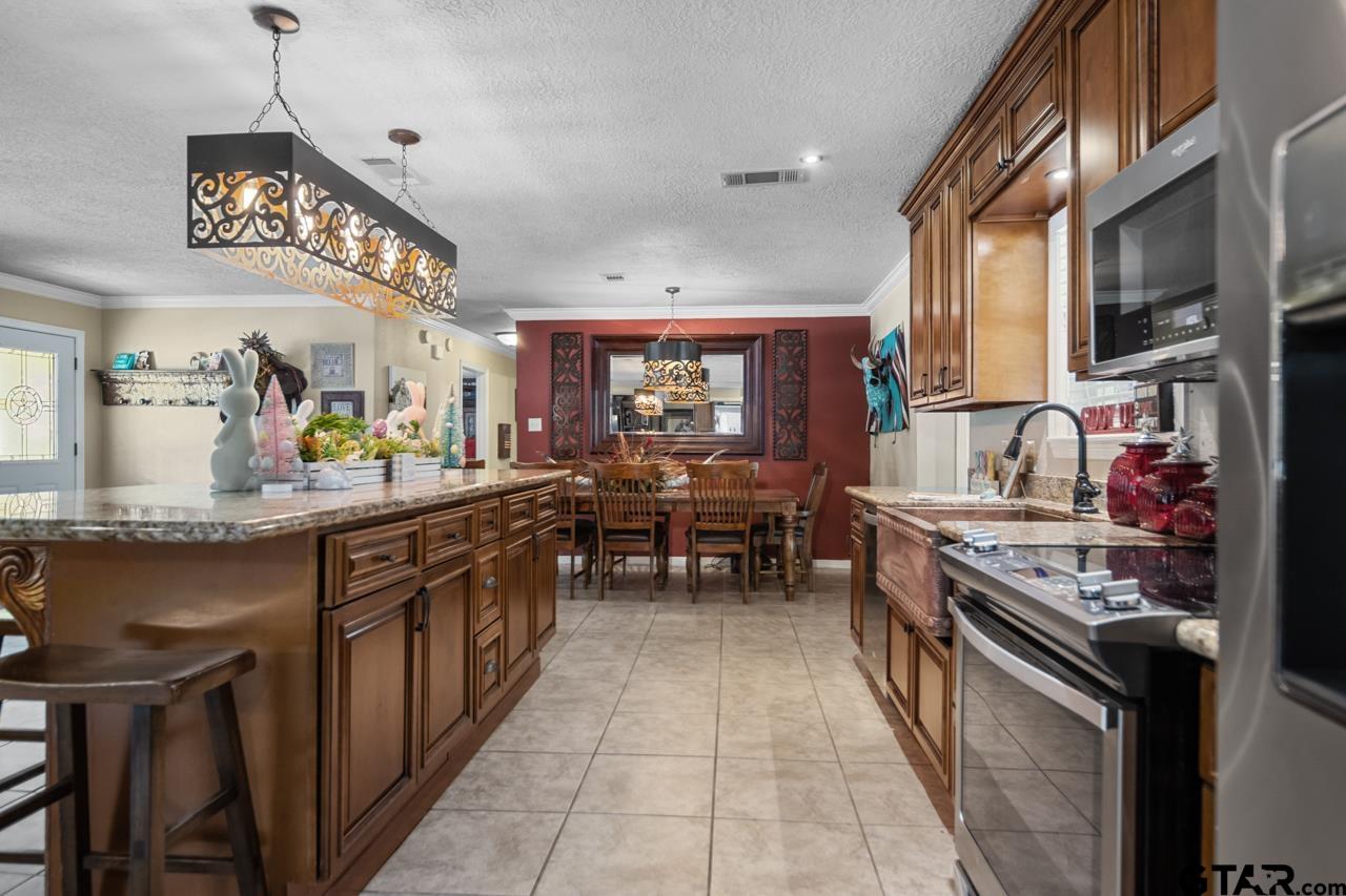 751 Houston Street Lovelady, TX 75851 - Photo 12 of 25 a kitchen with stainless steel appliances granite countertop a stove and cabinets