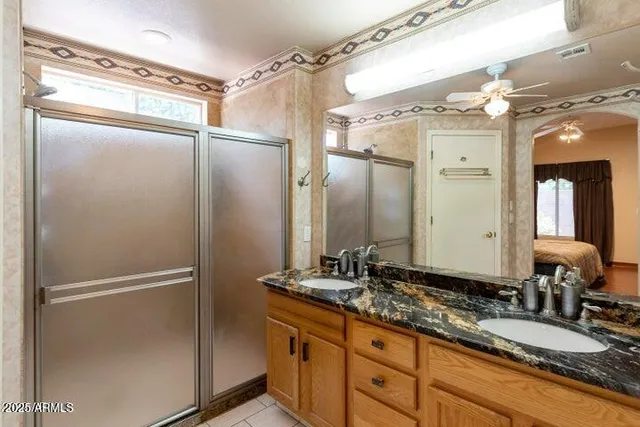 a bathroom with a granite countertop shower sink and mirror