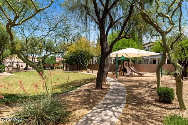 a view of a park with swings and large trees