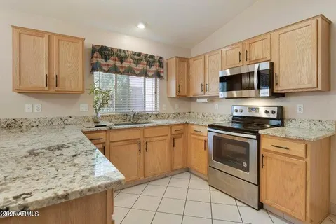 a kitchen with stainless steel appliances granite countertop a stove a sink and a microwave
