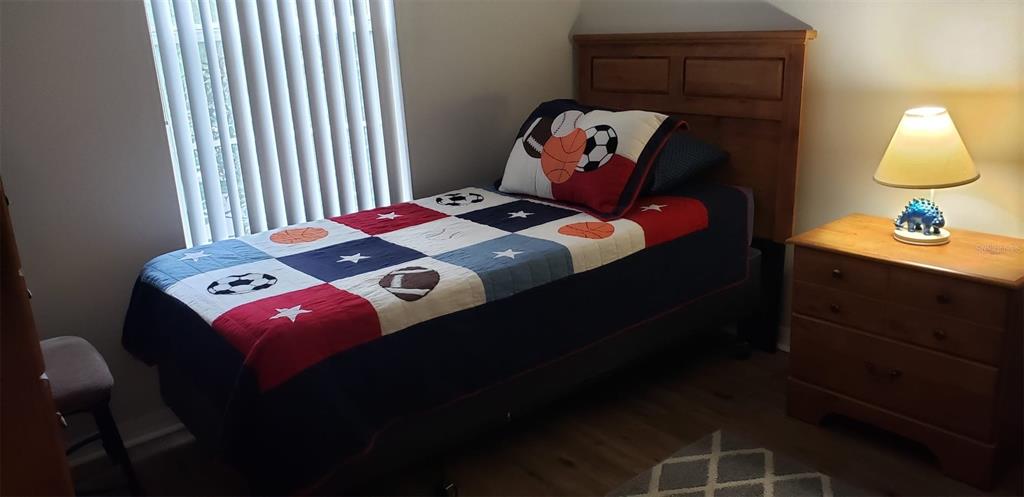 8521 Crystal Cove Loop Kissimmee, FL 34747 - Photo 11 of 23 a bedroom with a bed and a lamp on dresser