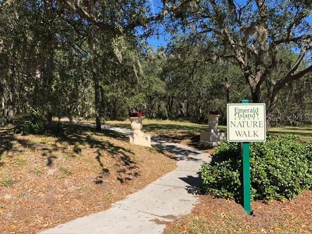 8521 Crystal Cove Loop Kissimmee, FL 34747 - Photo 16 of 23 a view of a street with benches sitting below a tree