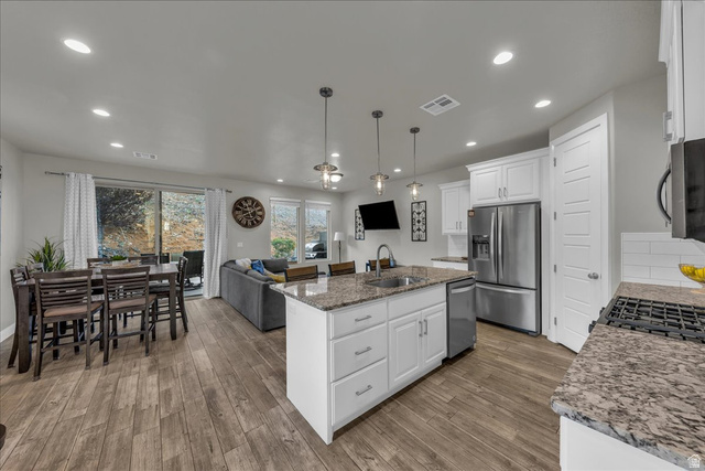 4796 Winged Foot Drive St. George, UT 84770 - Photo 33 of 33 Kitchen with open floor plan, white cabinetry, dark stone counters, and stainless steel appliances