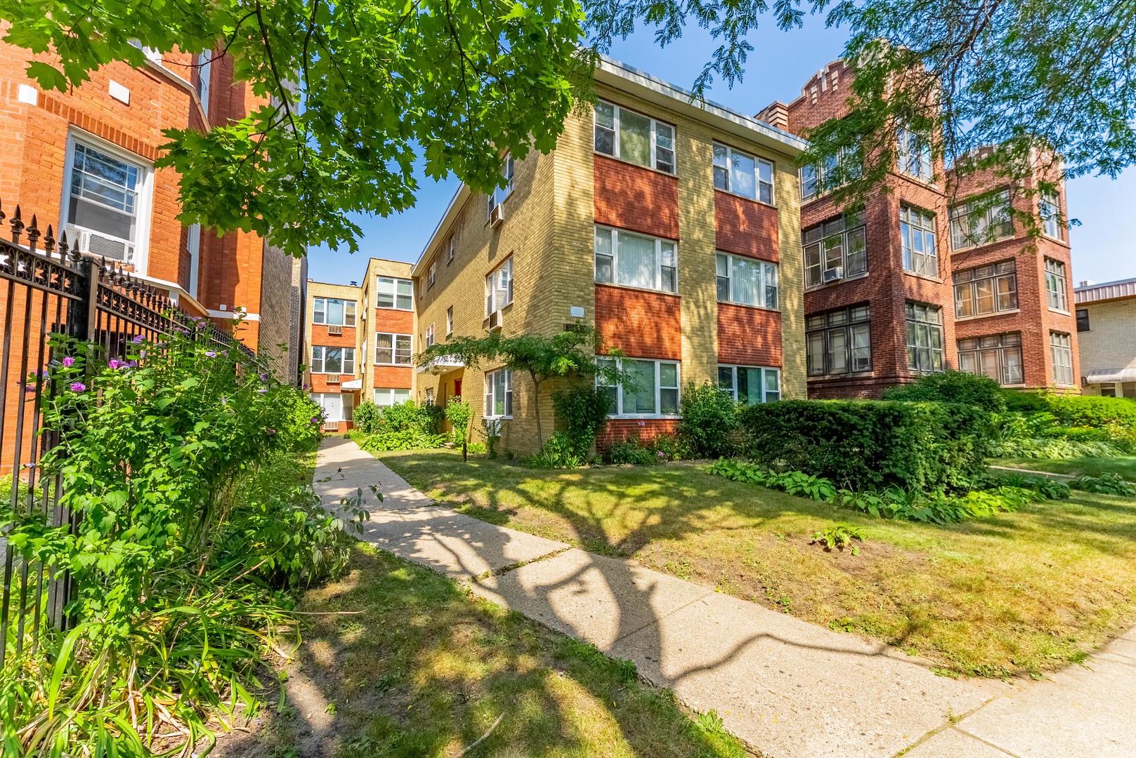 1630 West Chase Avenue, Unit 1N Chicago, IL 60626 - Photo 1 of 11 a view of yellow house with a yard and potted plants