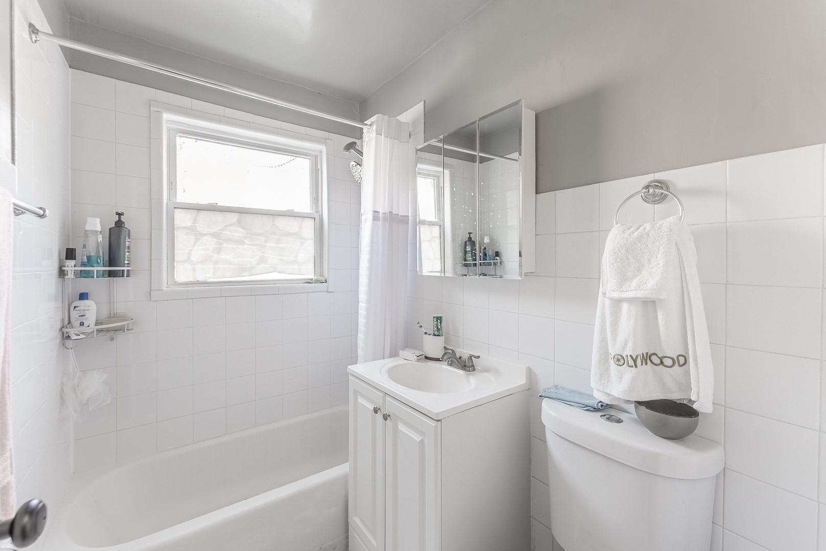 1630 West Chase Avenue, Unit 1N Chicago, IL 60626 - Photo 7 of 11 a bathroom with a sink a mirror and a bathtub