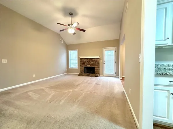 an empty room with fireplace and fan