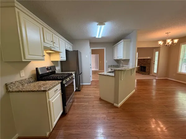 a view of a kitchen with wooden floor and a kitchen