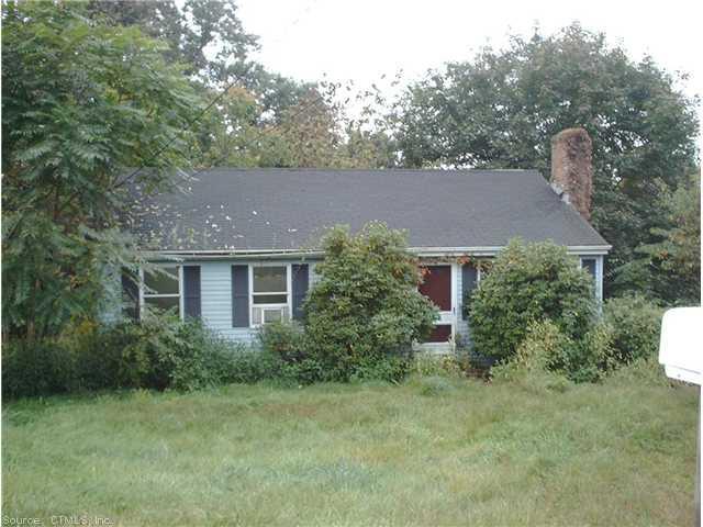 a aerial view of house with yard and trees in the background