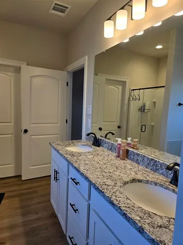 a bathroom with a granite countertop sink and a mirror