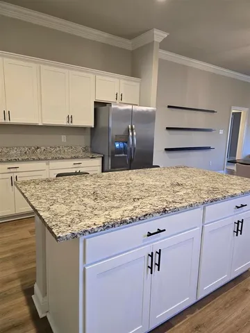 a kitchen with cabinets and wooden floor