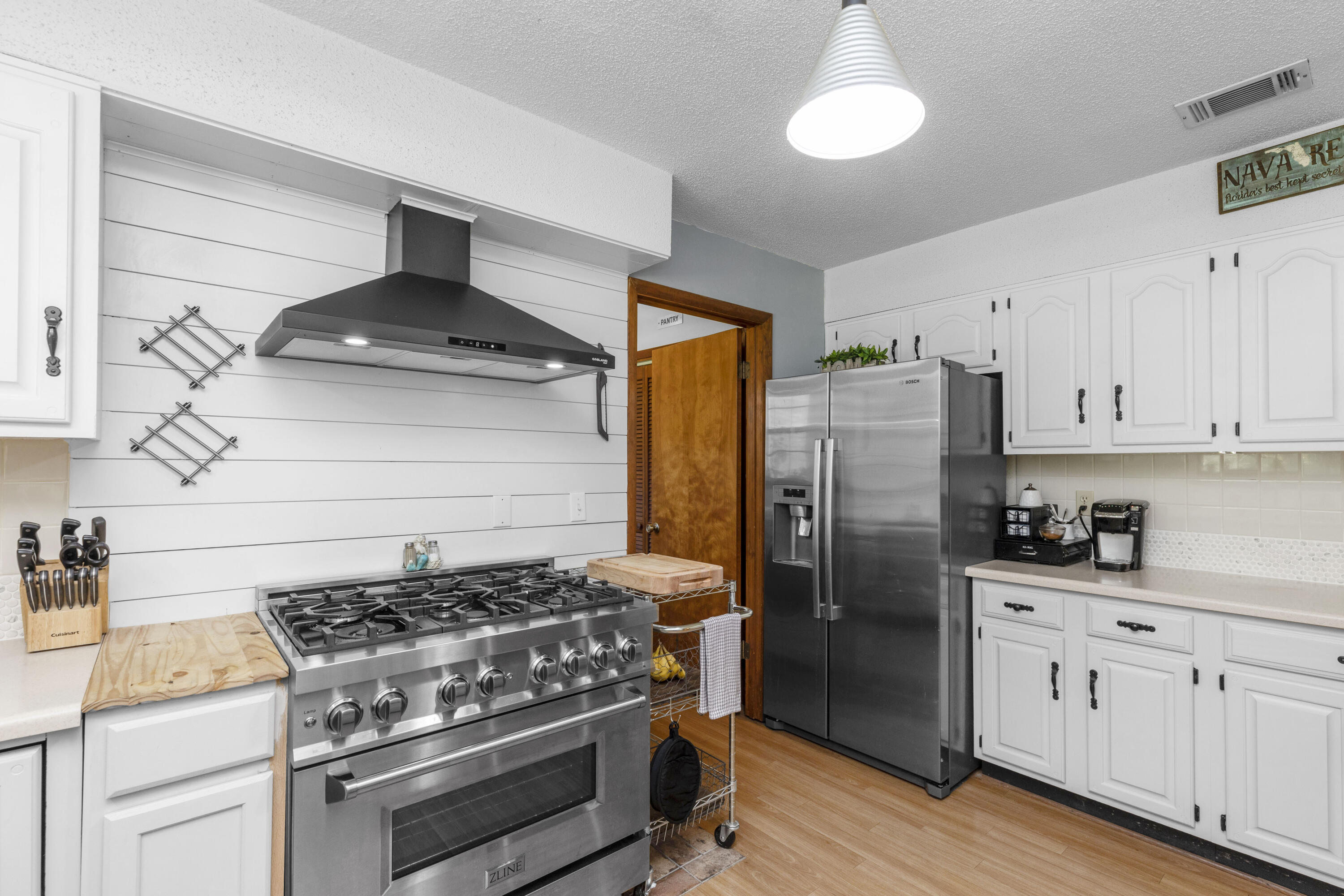 202 Wheeler Place Crestview, FL 32539 - Photo 11 of 40 a kitchen with stainless steel appliances a stove a refrigerator and a cabinets
