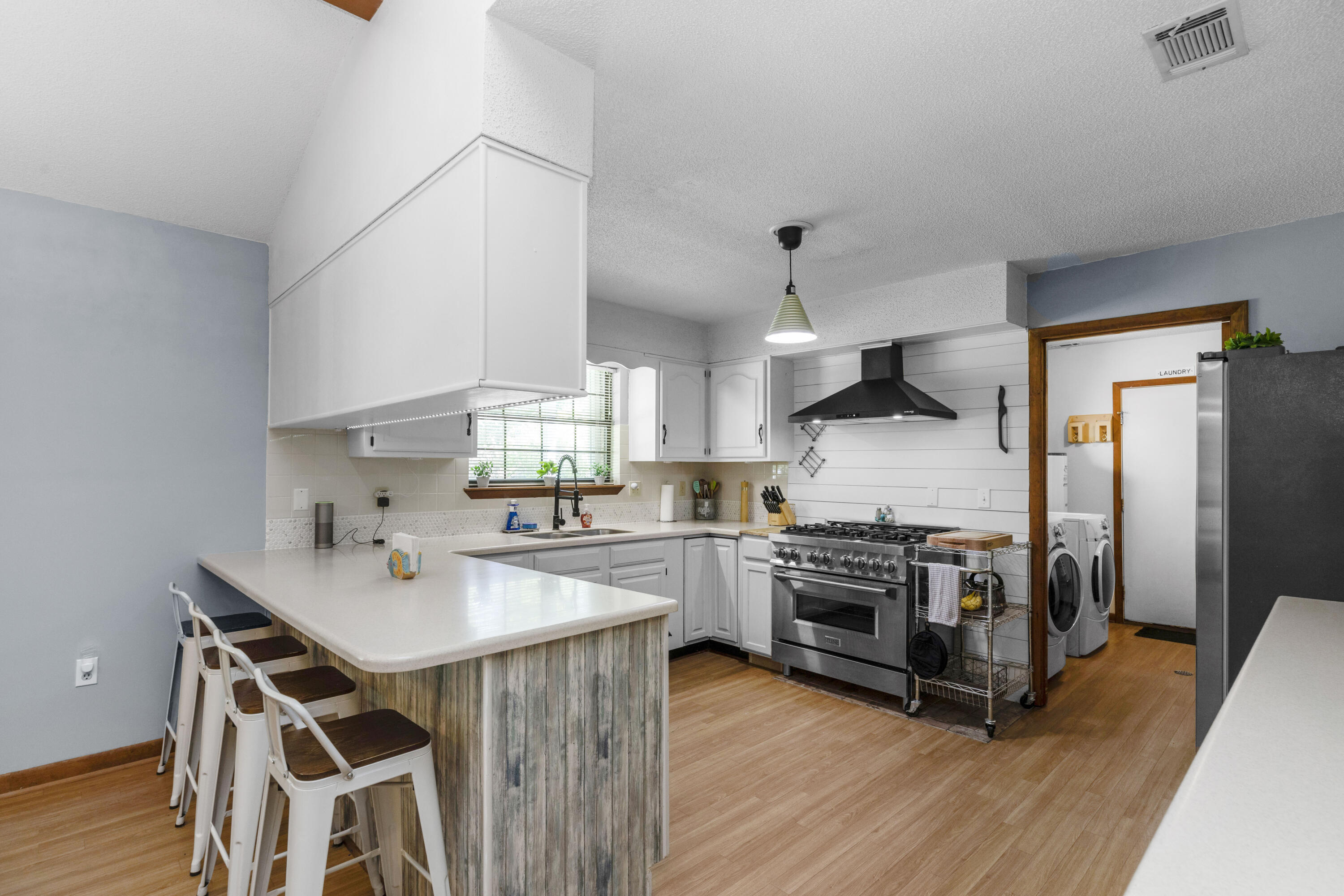 202 Wheeler Place Crestview, FL 32539 - Photo 13 of 40 a kitchen with stainless steel appliances a stove a sink dishwasher a refrigerator and white cabinets with wooden floor