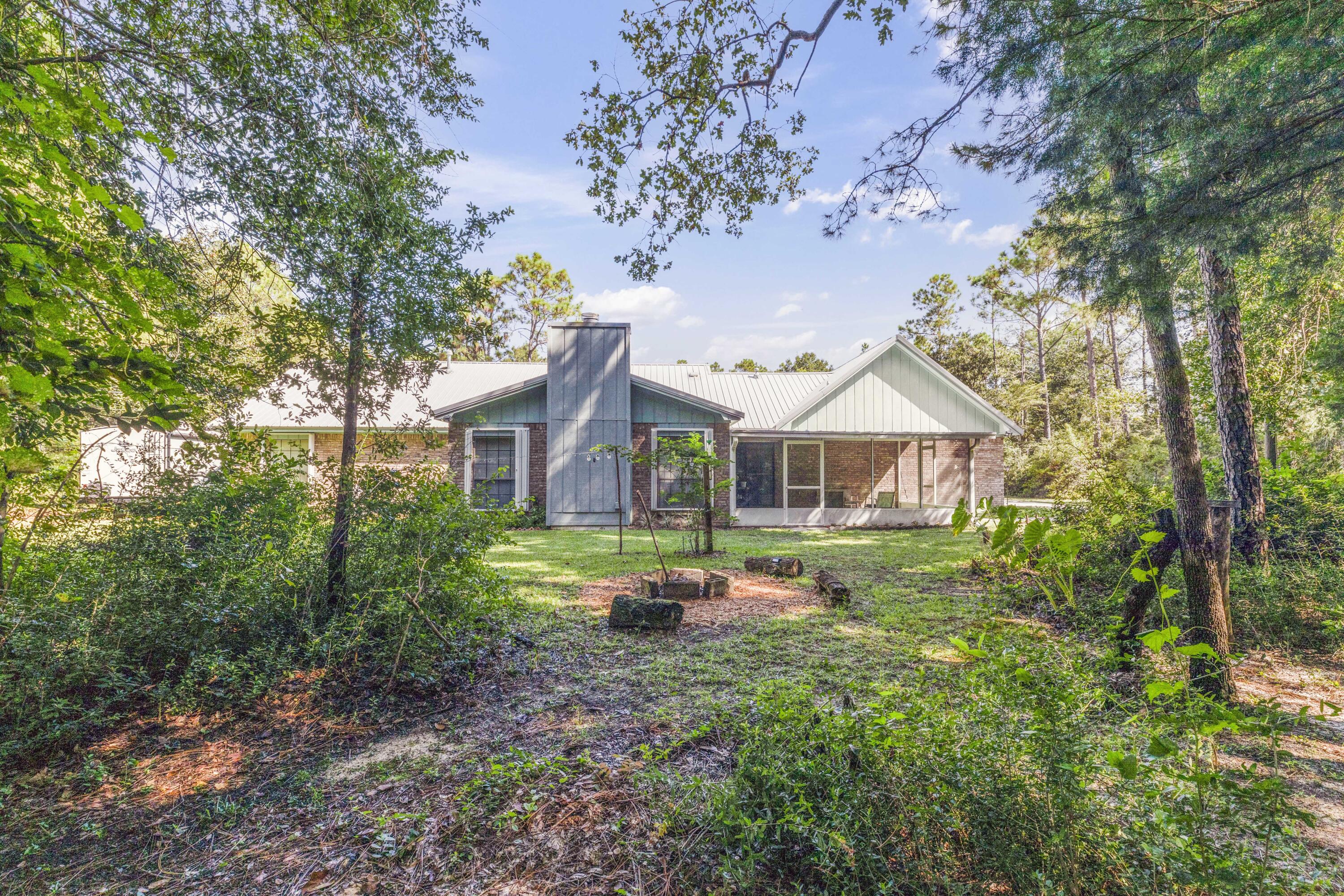 202 Wheeler Place Crestview, FL 32539 - Photo 34 of 40 a backyard of a house with table and chairs under an umbrella