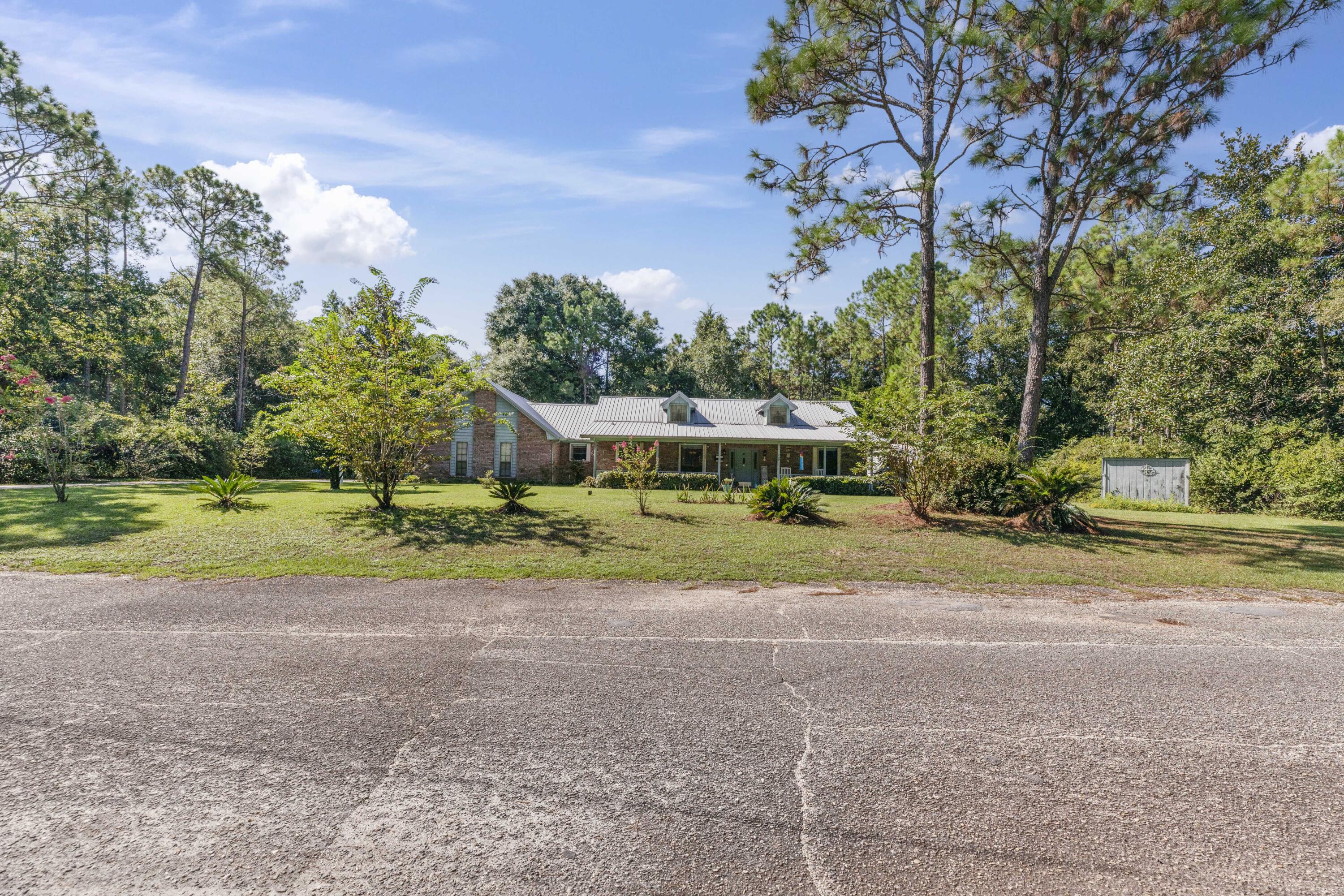202 Wheeler Place Crestview, FL 32539 - Photo 4 of 40 a view of a house with a yard and large trees