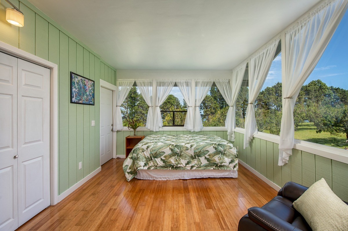 44-3265 Kalopa Mauka Road Honokaa, HI 96727 - Photo 19 of 30 a view of a bedroom with wooden floor and windows