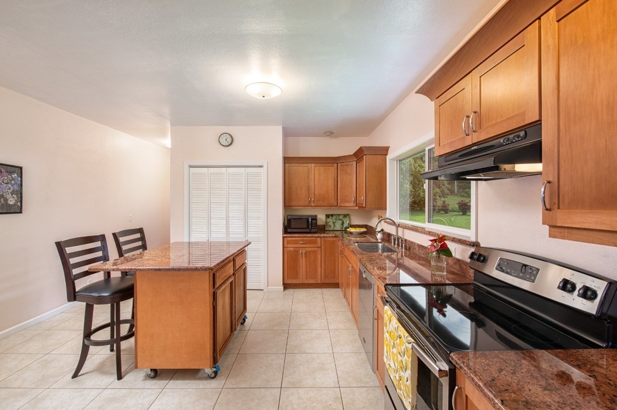 44-3265 Kalopa Mauka Road Honokaa, HI 96727 - Photo 10 of 30 a kitchen with a stove a sink and a refrigerator