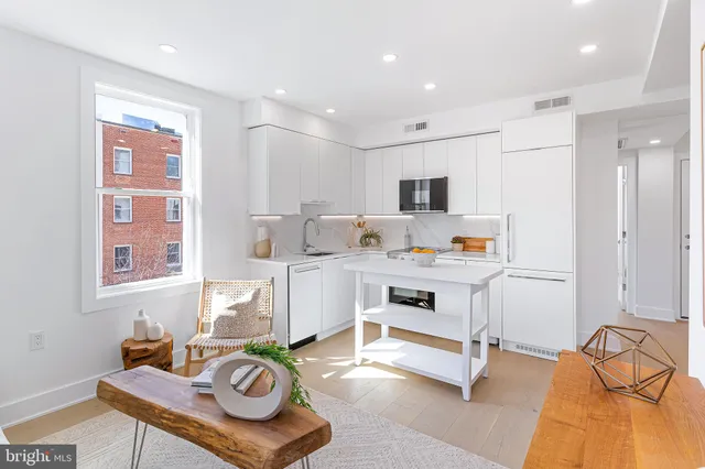 a living room with kitchen island furniture and a flat screen tv