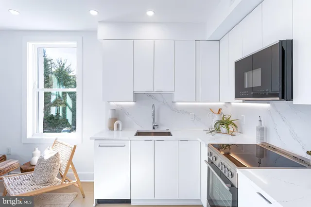 a kitchen with kitchen island granite countertop a sink and a stove top oven
