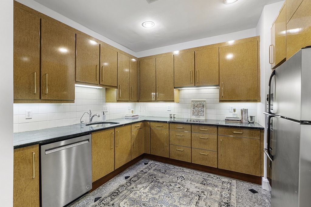 120 Beacon Street, Unit 3 Boston, MA 02116 - Photo 17 of 19 a kitchen with stainless steel appliances granite countertop wooden cabinets a sink and a large window