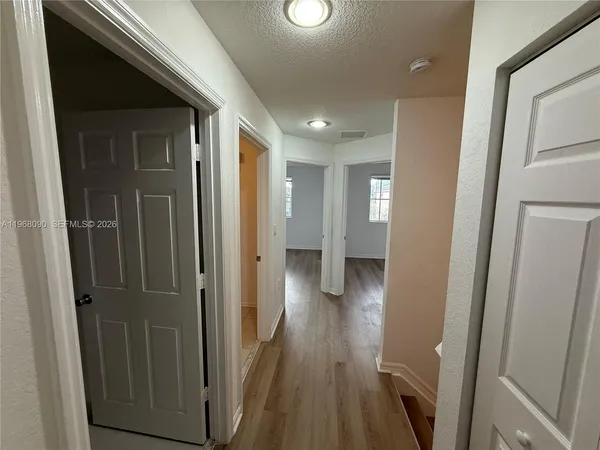 a view of a hallway with wooden floor