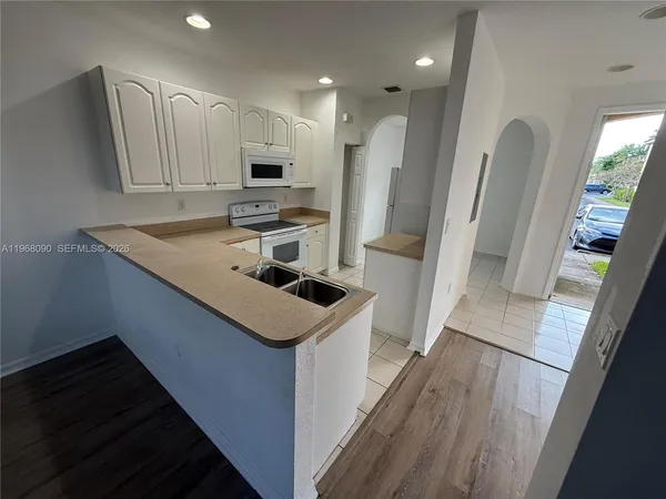 a kitchen with white cabinets appliances and sink