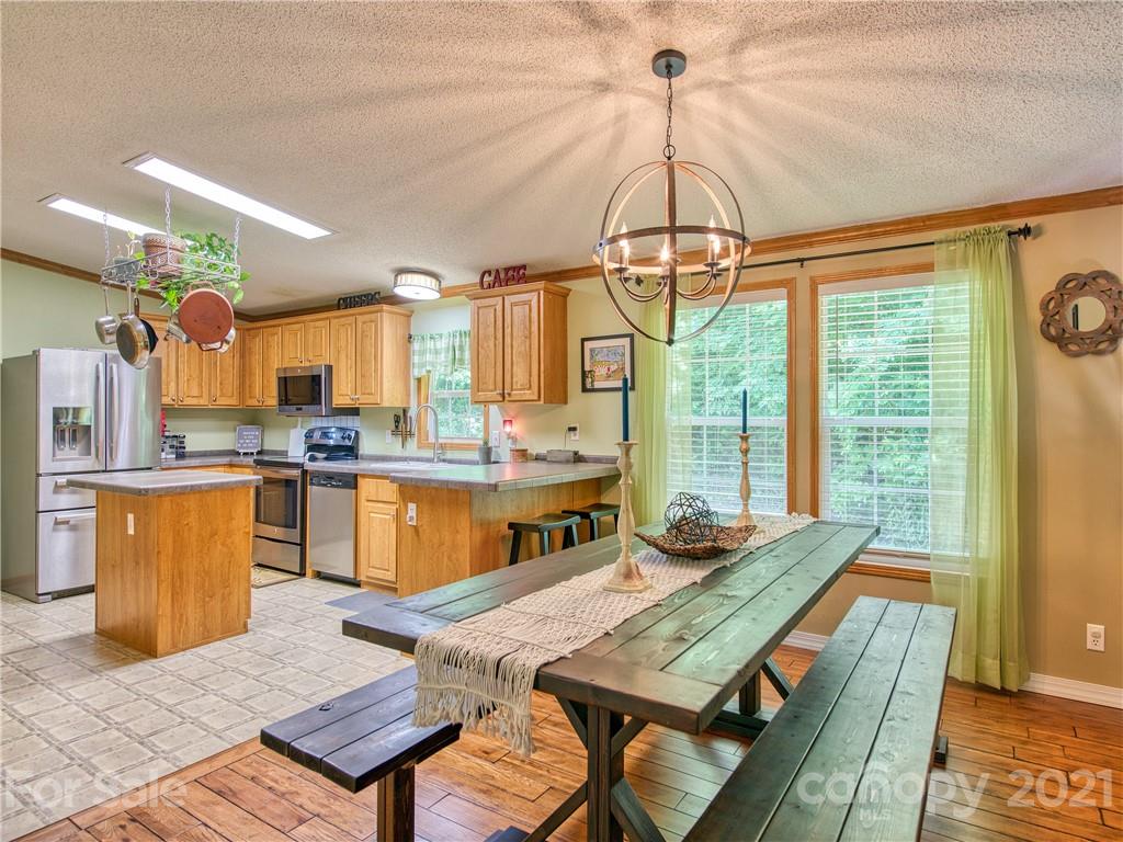485 Loop Road Clyde, NC 28721 - Photo 10 of 33 a kitchen with a table chairs and wooden floor