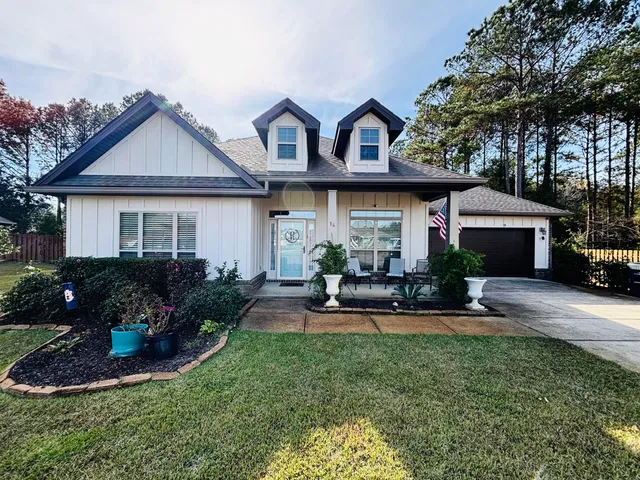 a front view of a house with sitting area and garden