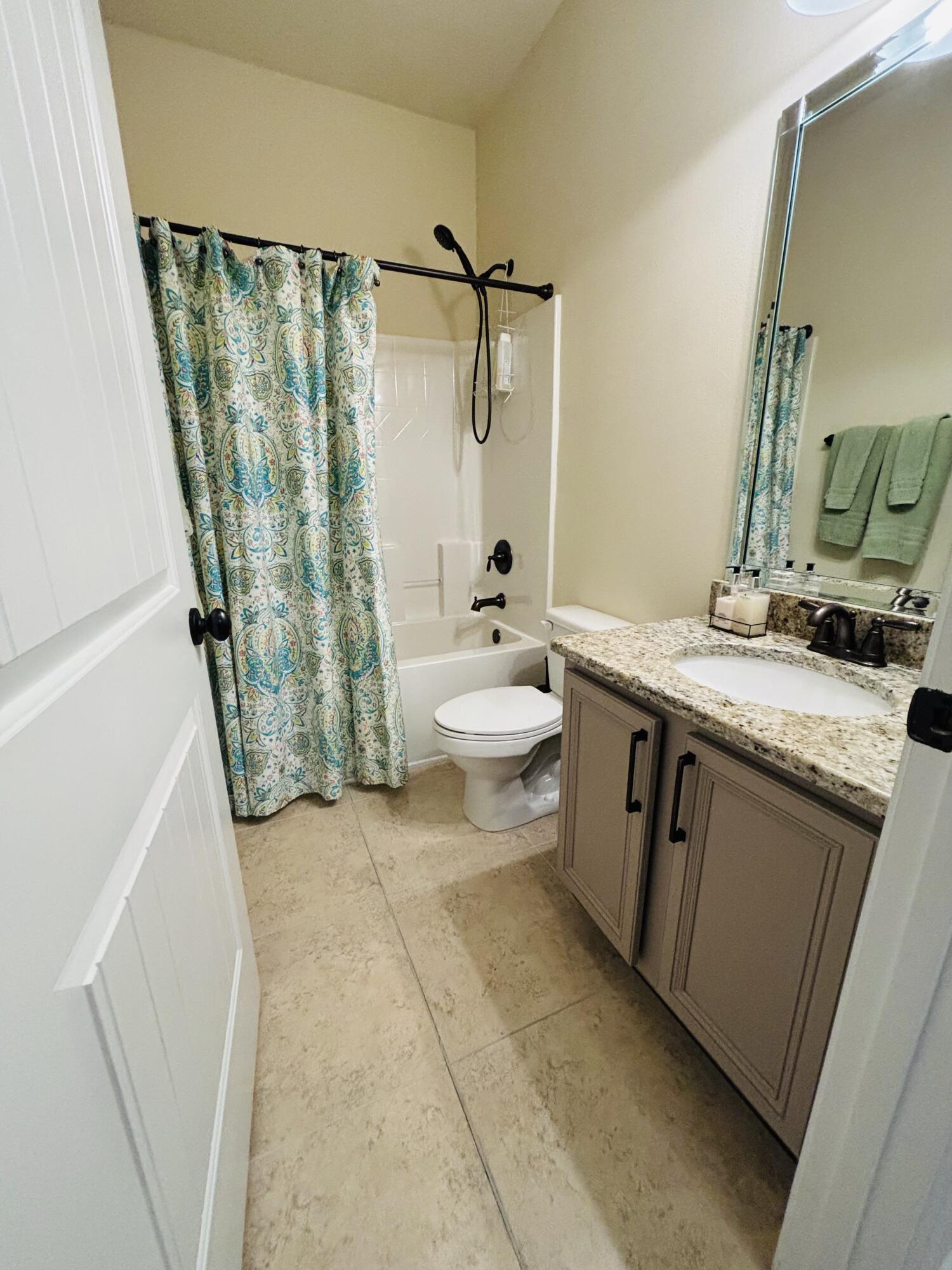 14 Lullaby Lane Freeport, FL 32439 - Photo 7 of 15 a bathroom with a granite countertop sink a toilet and shower