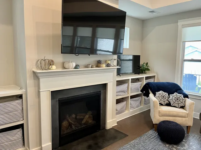 a living room with furniture a flat screen tv and a fireplace