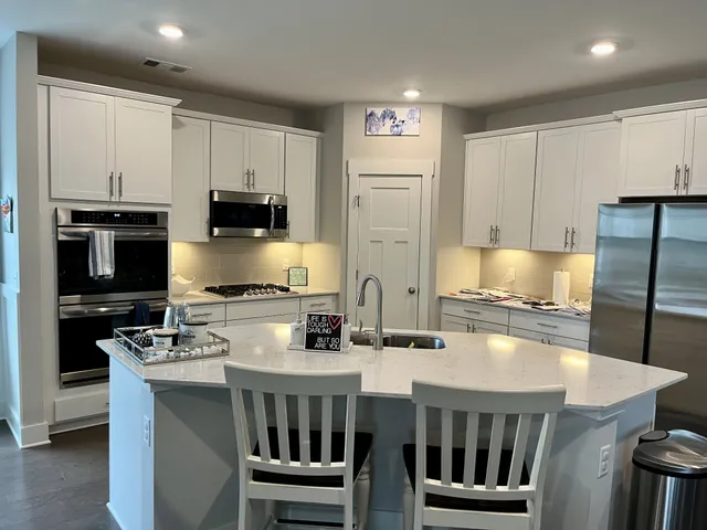 a kitchen with kitchen island granite countertop a refrigerator stove microwave and cabinets