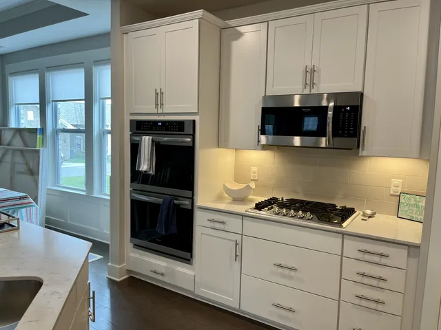 a kitchen with white cabinets and black appliances