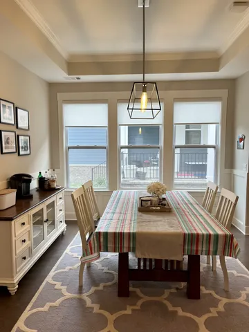 a kitchen with stainless steel appliances a dining table chairs refrigerator and sink